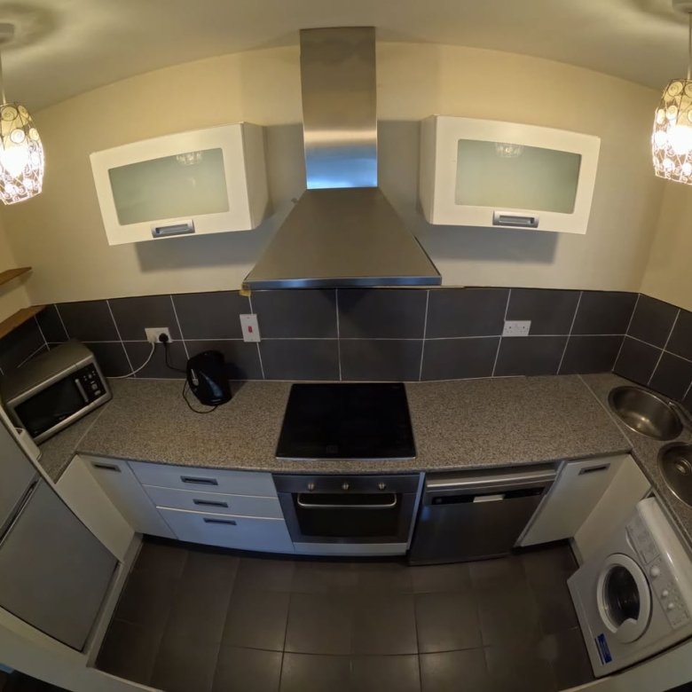 Compact kitchen with stainless steel appliances and modern design.