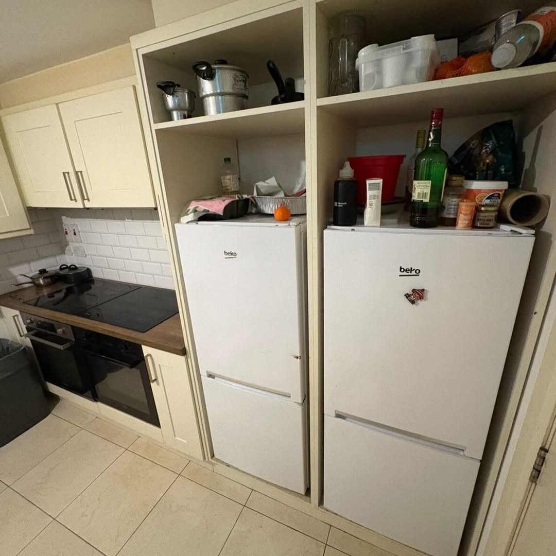 Modern kitchen with two white Beko fridge freezers and overhead storage cabinets.