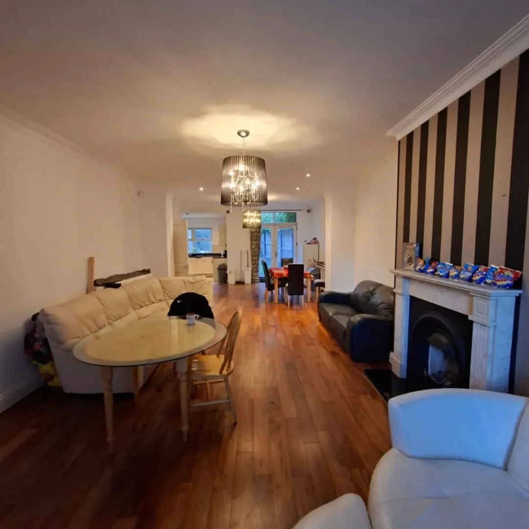 Open concept living room with dining area, fireplace, and hardwood floors.