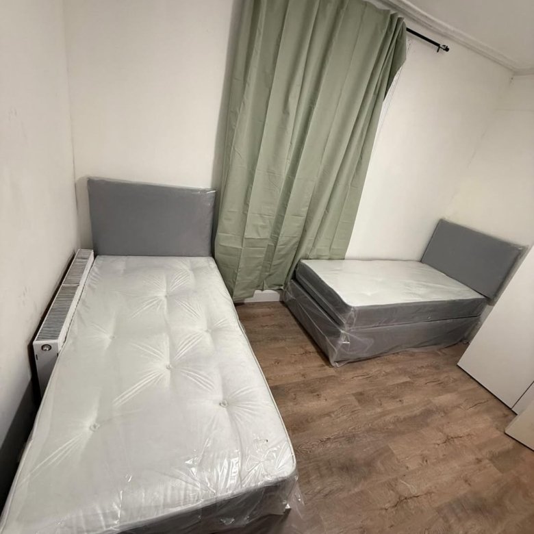 Two single beds with grey headboards in a room.