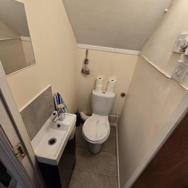 Small bathroom with toilet, sink, and angled ceiling.