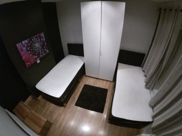 Small bedroom with two single beds and a wardrobe.