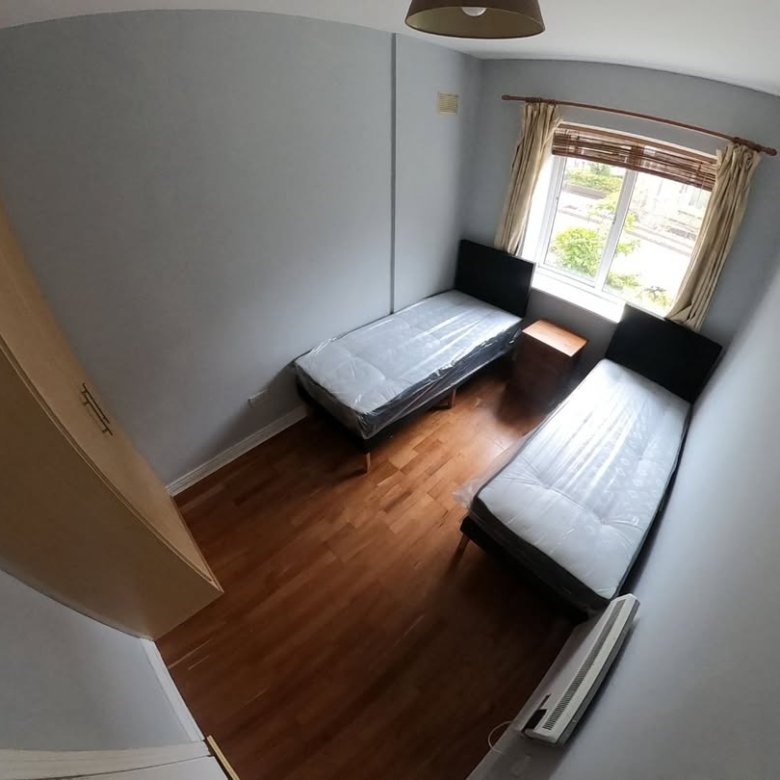 Bedroom with two single beds, wardrobe, and window.