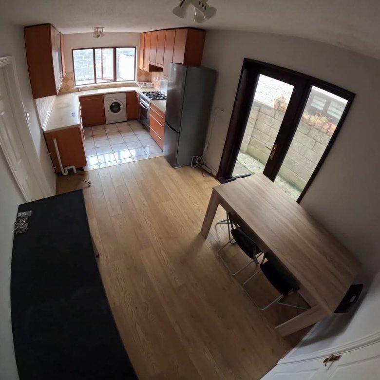 Bright kitchen with wood cabinets, table, and chairs near patio doors.