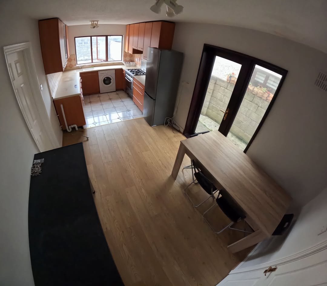Bright kitchen with wood cabinets, table, and chairs near patio doors.