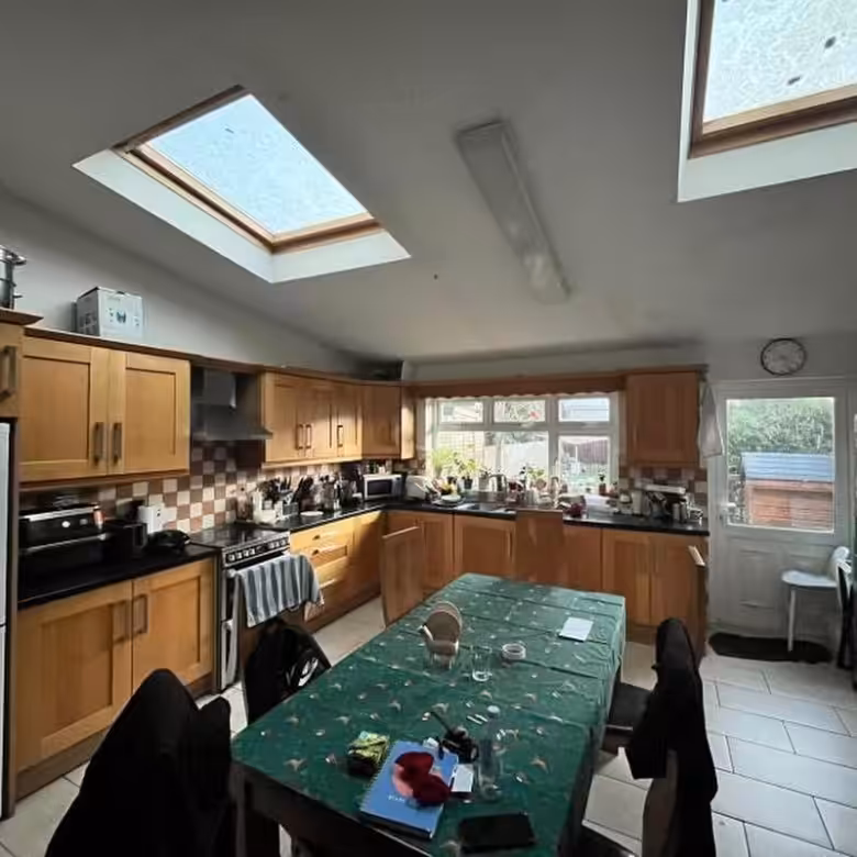 Bright kitchen with skylights, wooden cabinets, and dining table.