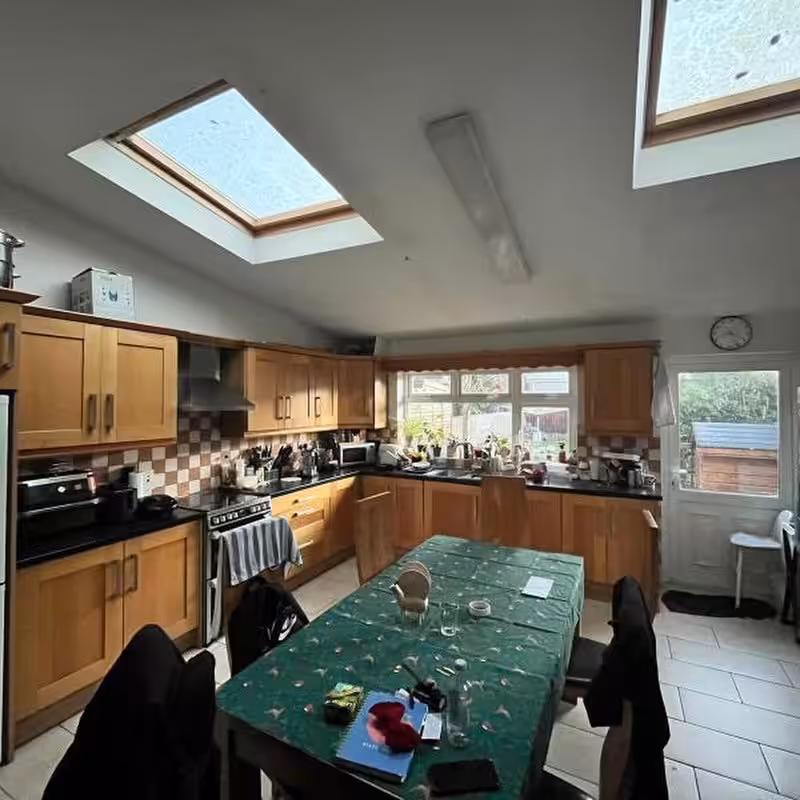 Bright kitchen with skylights, wooden cabinets, and dining table.