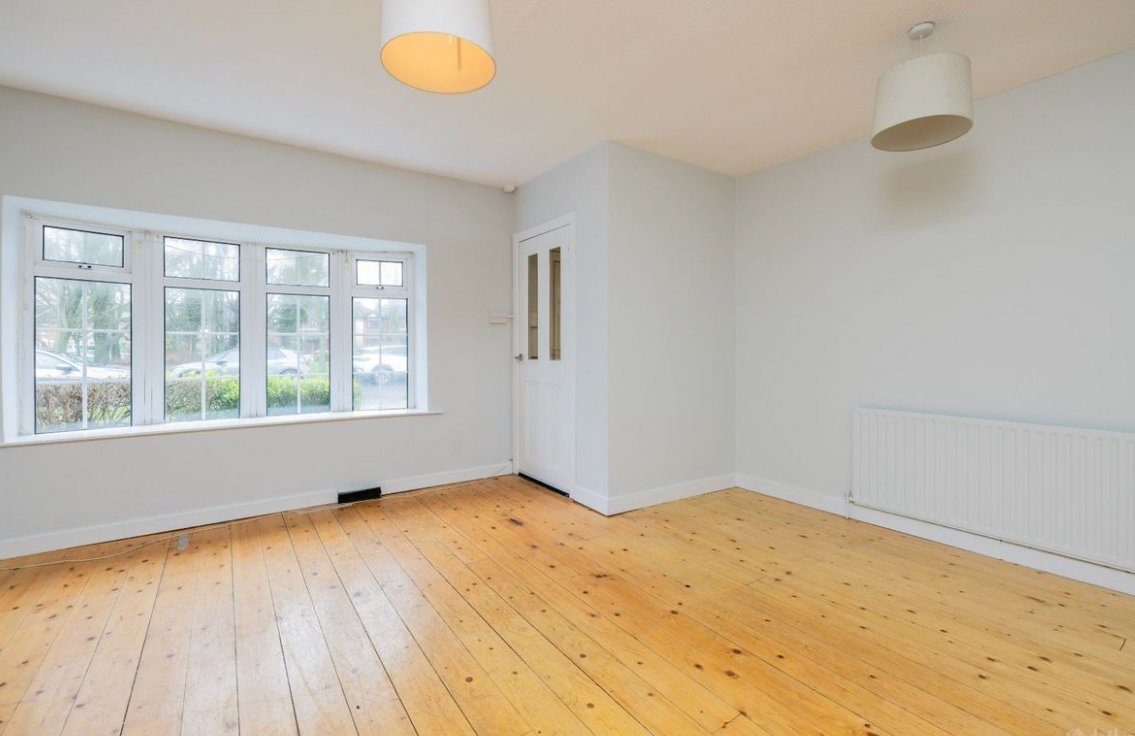 Bright room with wood floor, window, and white door. Interior design.