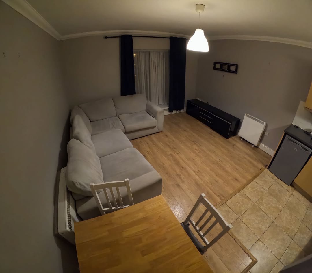 Cozy living room with sectional sofa, wood floors, and dining table.