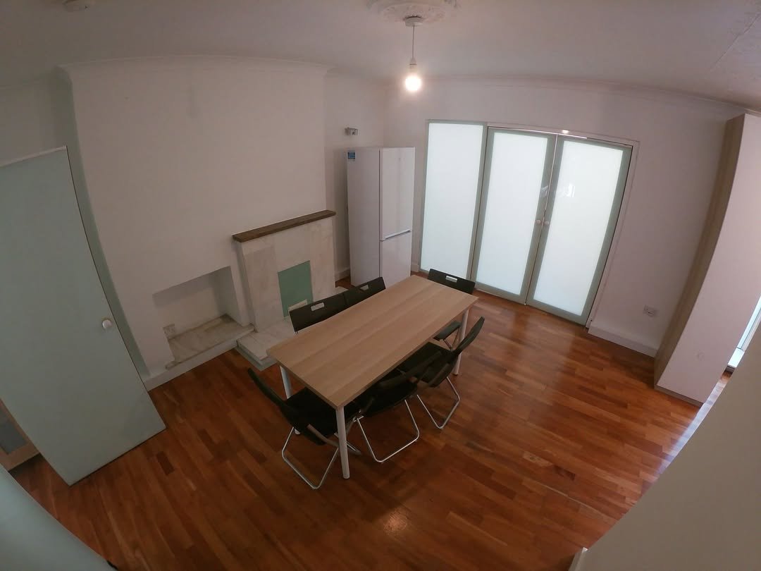 Dining room with table, chairs, fireplace, wood floor, and sliding glass doors.