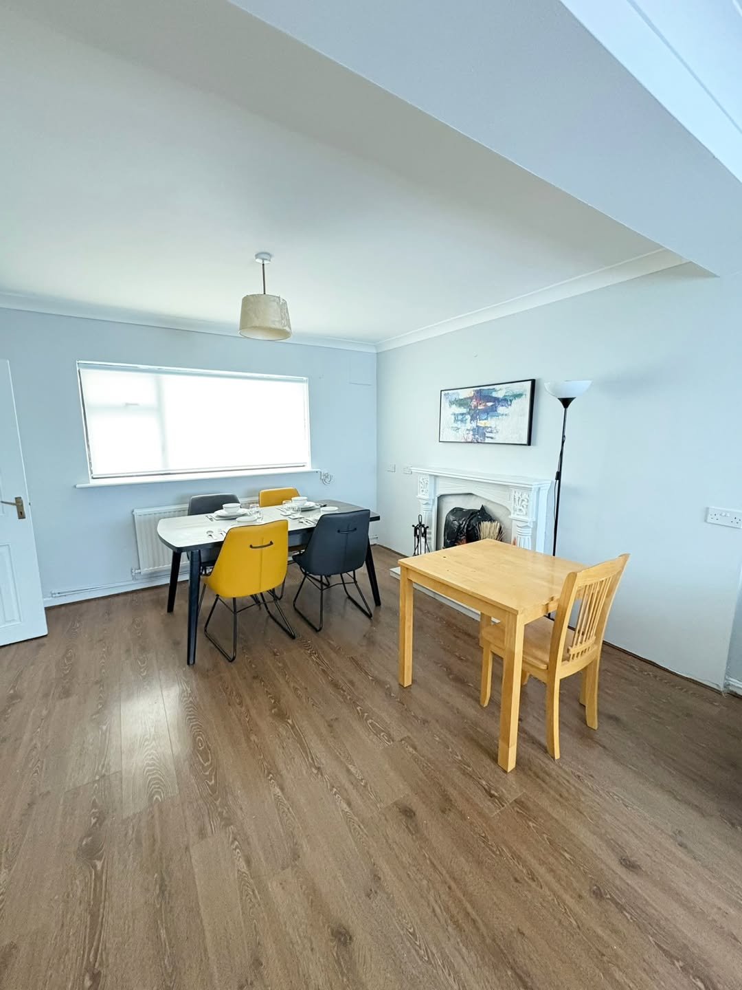 Dining room with table, chairs, fireplace, and light wood floors.