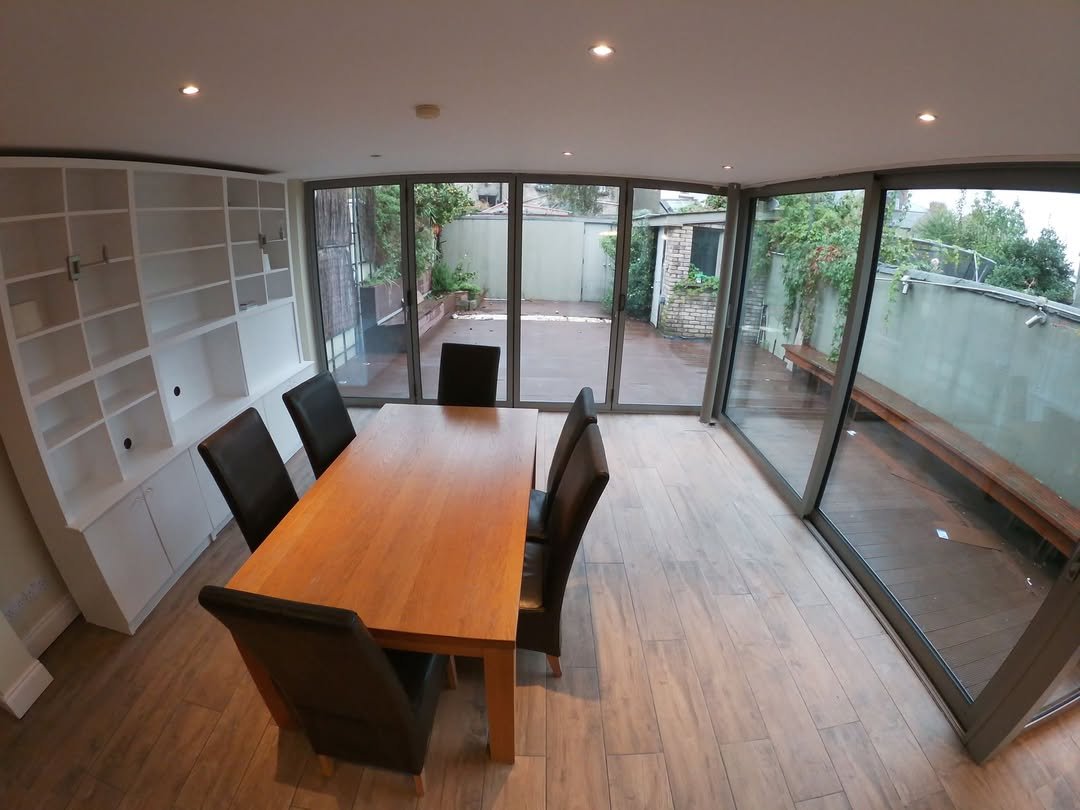 Dining room with wood table, leather chairs, built-in shelves, and patio doors.