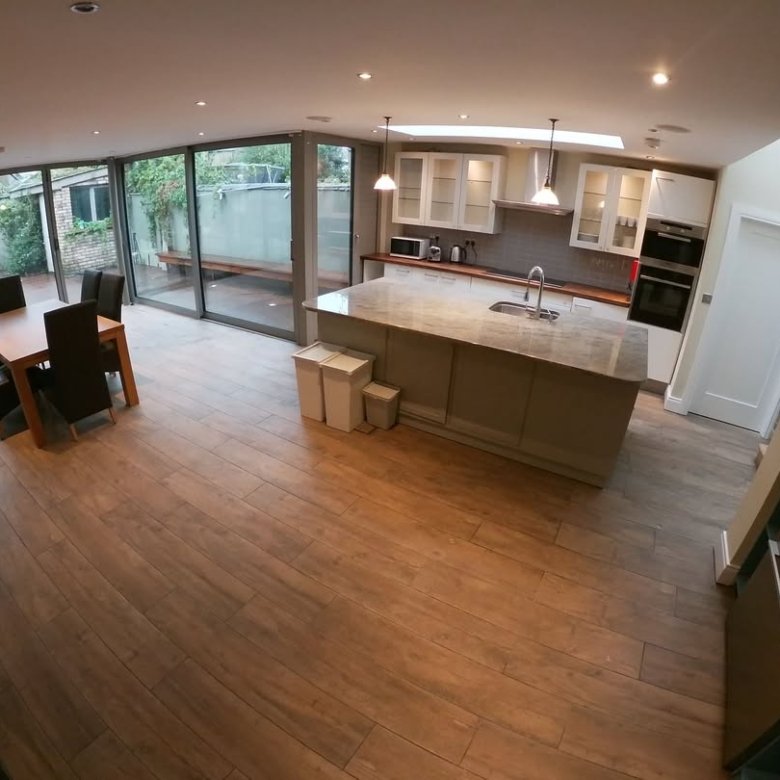 Spacious modern kitchen with island, dining area, and garden view.