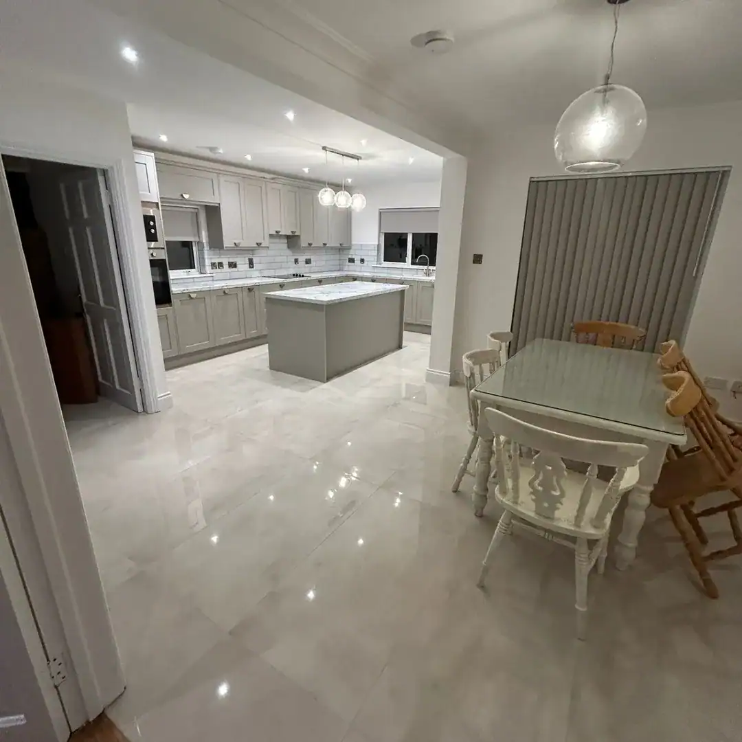 Bright, modern kitchen with island, dining table, and pendant light.