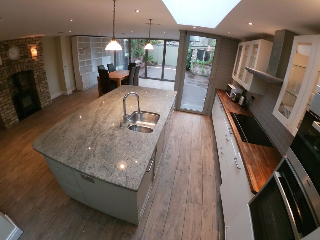 Modern kitchen with island, stainless steel appliances, and skylight.