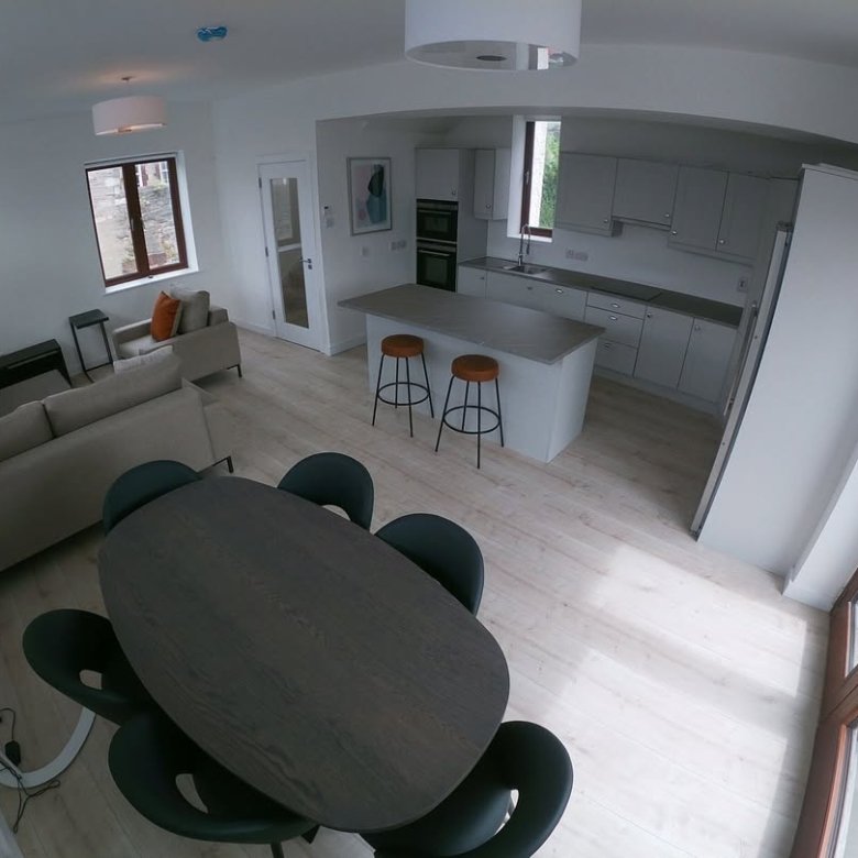Open concept kitchen and living area with dining table and modern decor.
