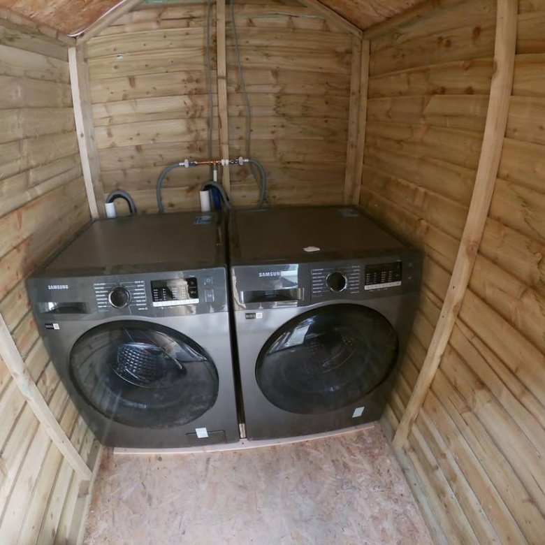 Two Samsung washing machines installed inside a wooden shed.