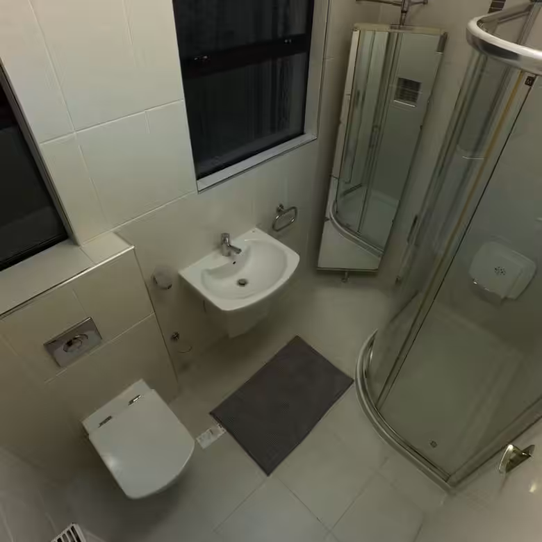 Compact bathroom with toilet, sink, shower, and window. Neutral color scheme, clean design.