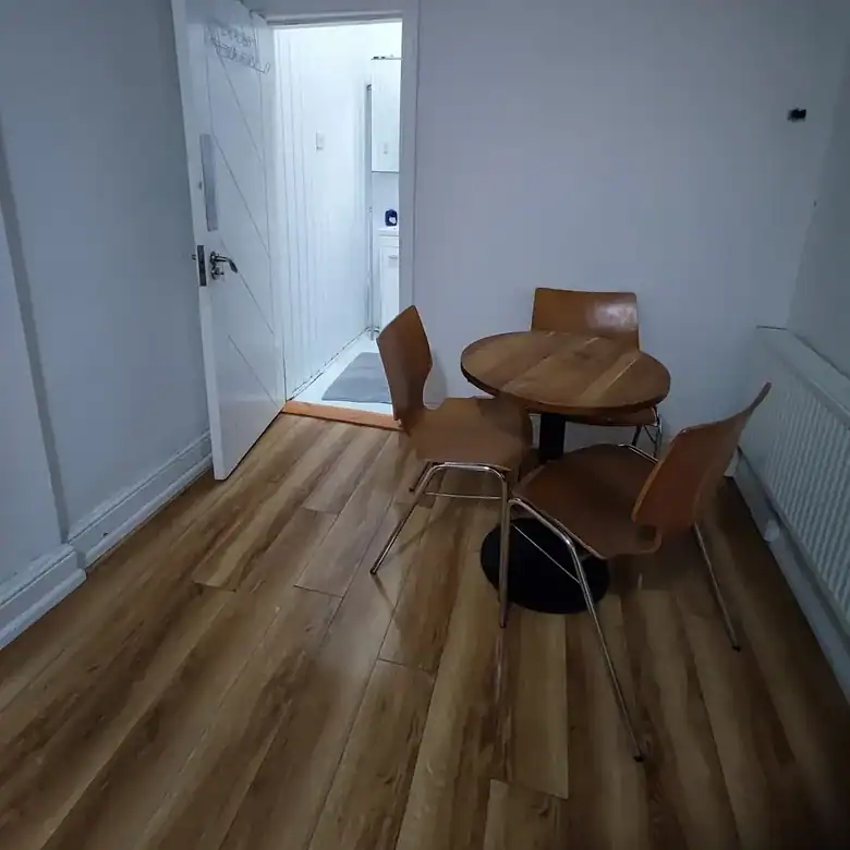 Small dining area with round table and three chairs in a modern apartment.