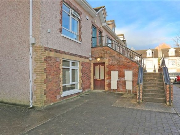 Exterior view of a two-story apartment building with brick and stairs.