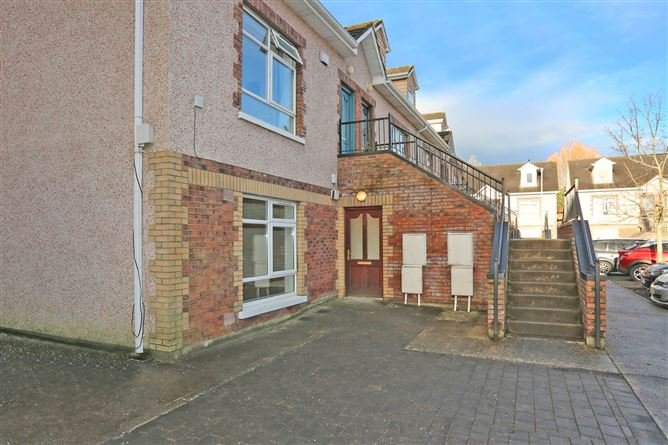 Exterior view of a two-story apartment building with brick and stairs.