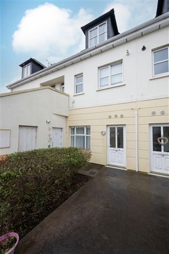 Exterior of a two-story townhouse with a small garden area.