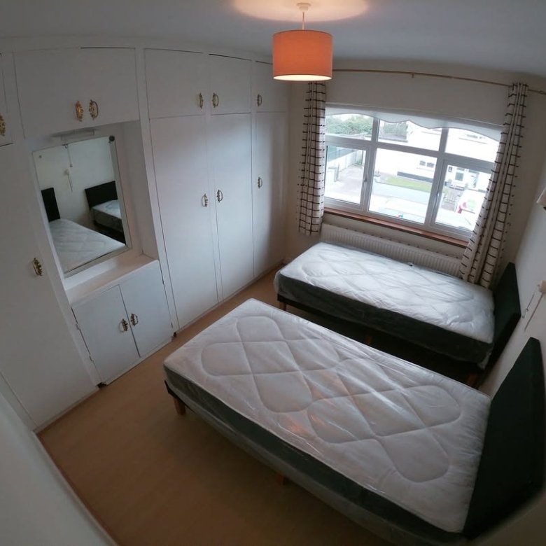 Bedroom with two single beds, built-in wardrobe, and window.