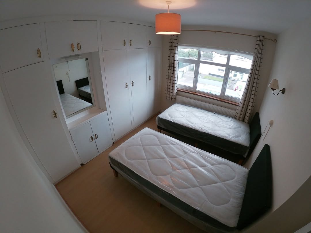 Bedroom with two single beds, built-in wardrobe, and window.