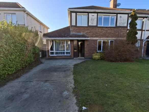 Two-story brick house with front lawn and driveway on a sunny day.