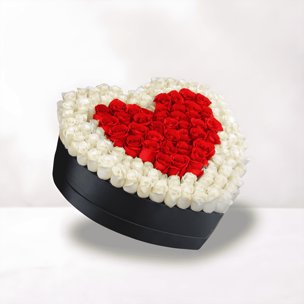 Heart-shaped flower box with red roses inside white roses, perfect for romantic occasions.