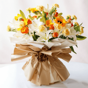 Bright floral arrangement with sunlit yellow, white, and orange blooms in elegant wrapping.