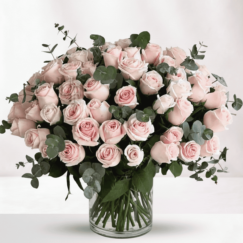 Elegant pink roses bouquet with eucalyptus in a glass vase.