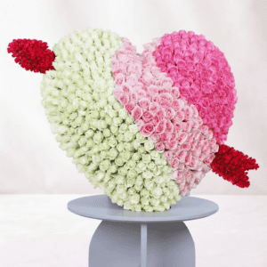 Shaped floral arrangement with white, pink, and red roses.