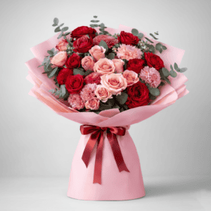 Beautiful mixed flower bouquet with roses and carnations in pink and red shades.