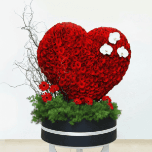 Shaped floral arrangement with red roses and white orchids.