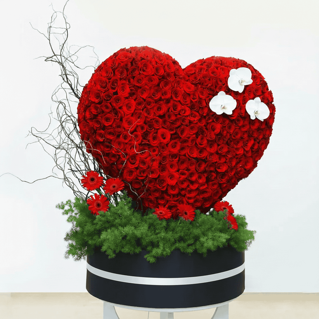 Shaped floral arrangement with red roses and white orchids.