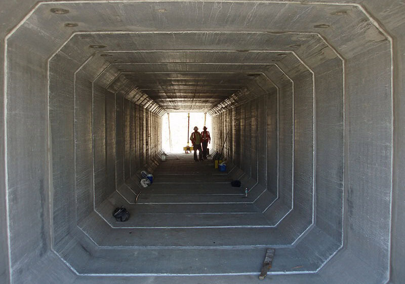 Precast concrete tunnel with workers inspecting construction, showcasing durable and high-quality concrete infrastructure from Global Precast.