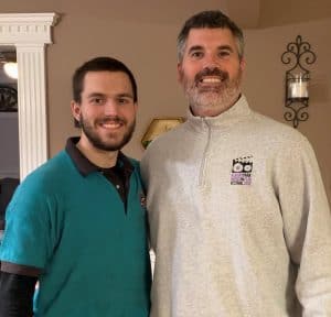 %Focuskw% | Good Tidings Plumbing, Heating &Amp; Cooling Two men stand side by side indoors, smiling at the camera. One wears a teal shirt, the other a light gray pullover.