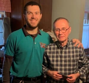 %Focuskw% | Good Tidings Plumbing, Heating &Amp; Cooling Two men stand indoors, one wearing a teal uniform shirt and the other in a checkered shirt, posing and smiling at the camera.
