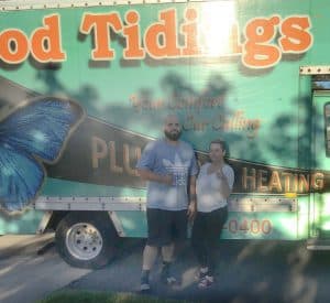 %Focuskw% | Good Tidings Plumbing, Heating &Amp; Cooling Two people stand in front of a turquoise service truck with "Good Tidings" and a butterfly graphic on the side.