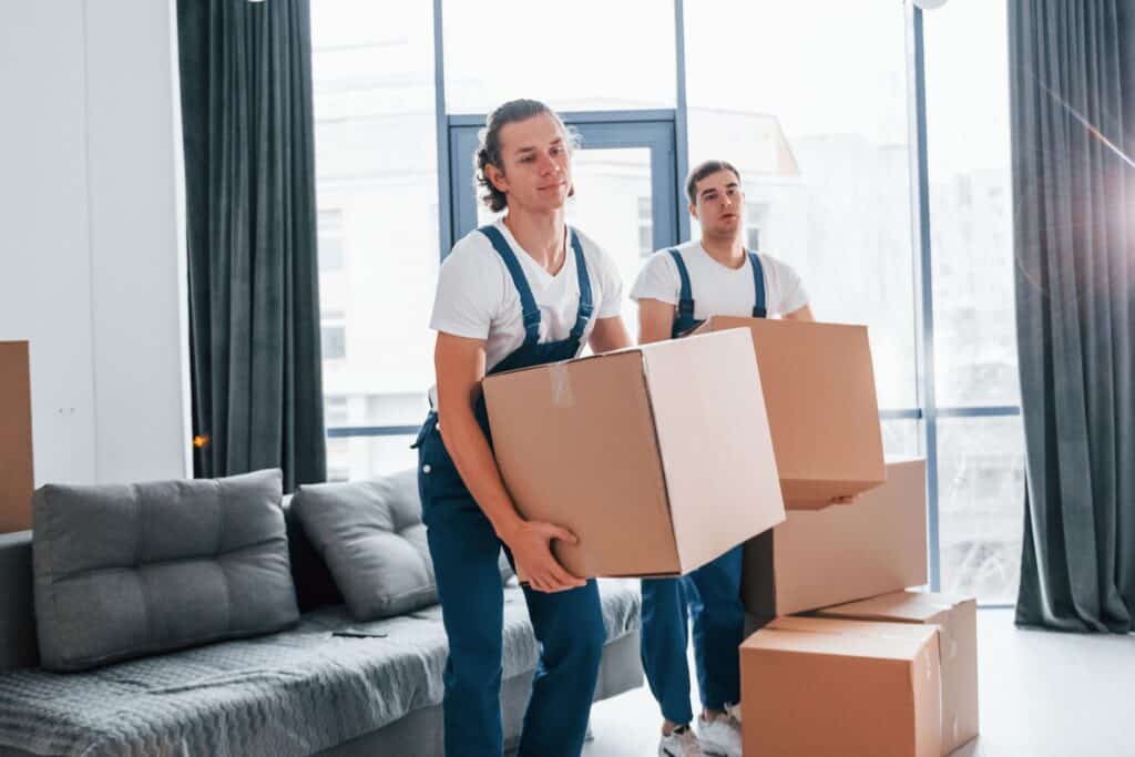 Two movers carrying boxes in a modern apartment in Aberdeen.