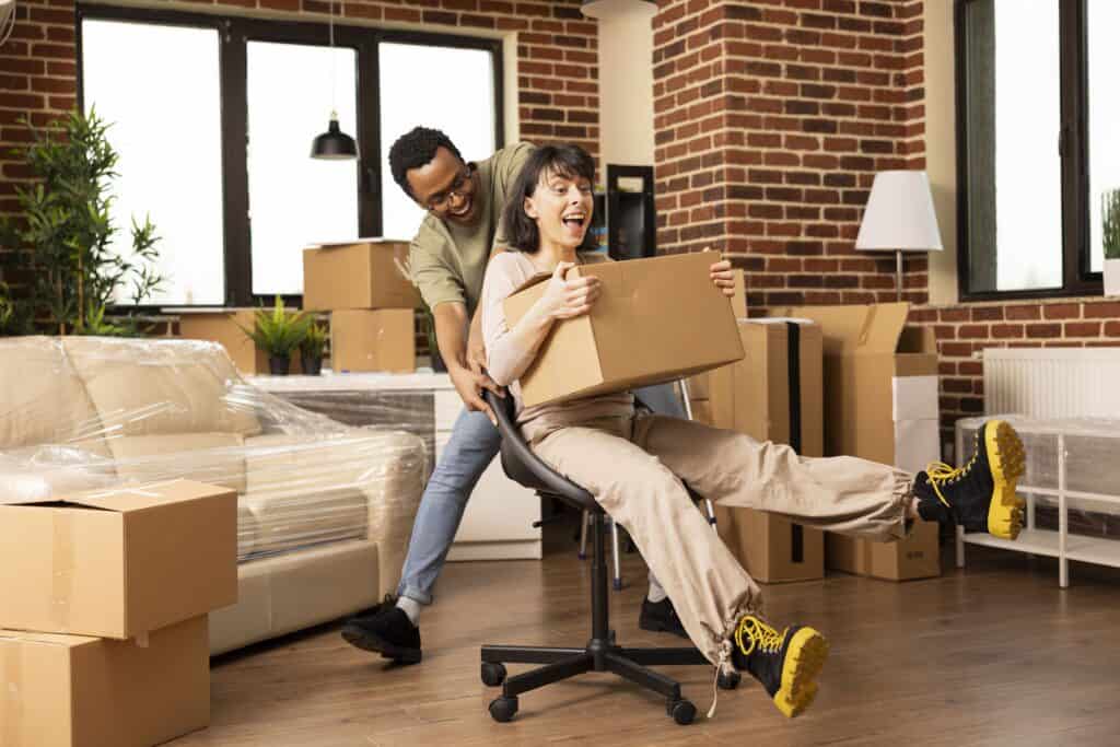 Happy movers packing boxes in a modern apartment in Abbey.