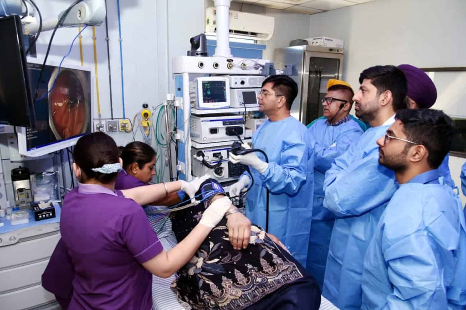 Medical team performing a procedure in a hospital setting.