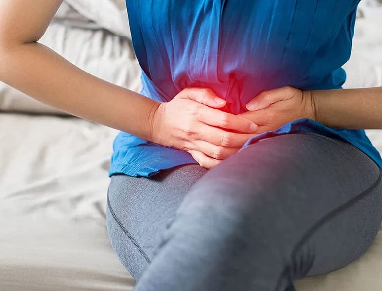 Woman experiencing menstrual pain holding her lower abdomen.