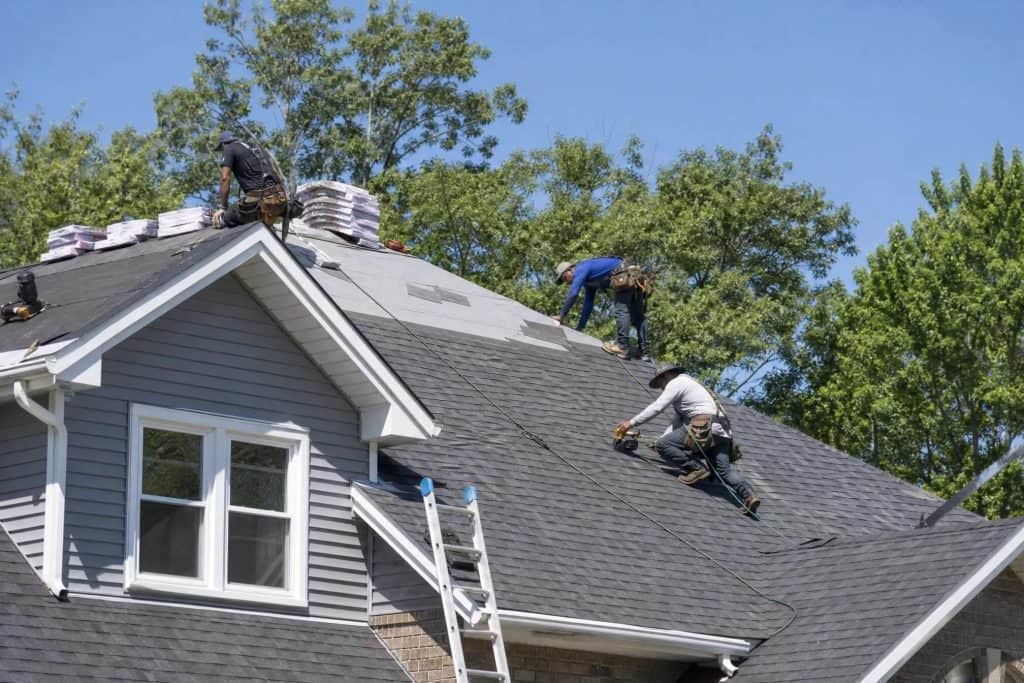 GRT Roofing crew safely repairs a home's roof, showing teamwork and care for quality work on a clear, sunny day. GRT Roofing crew safely repairs a home's roof, showing teamwork and care for quality work on a clear, sunny day.