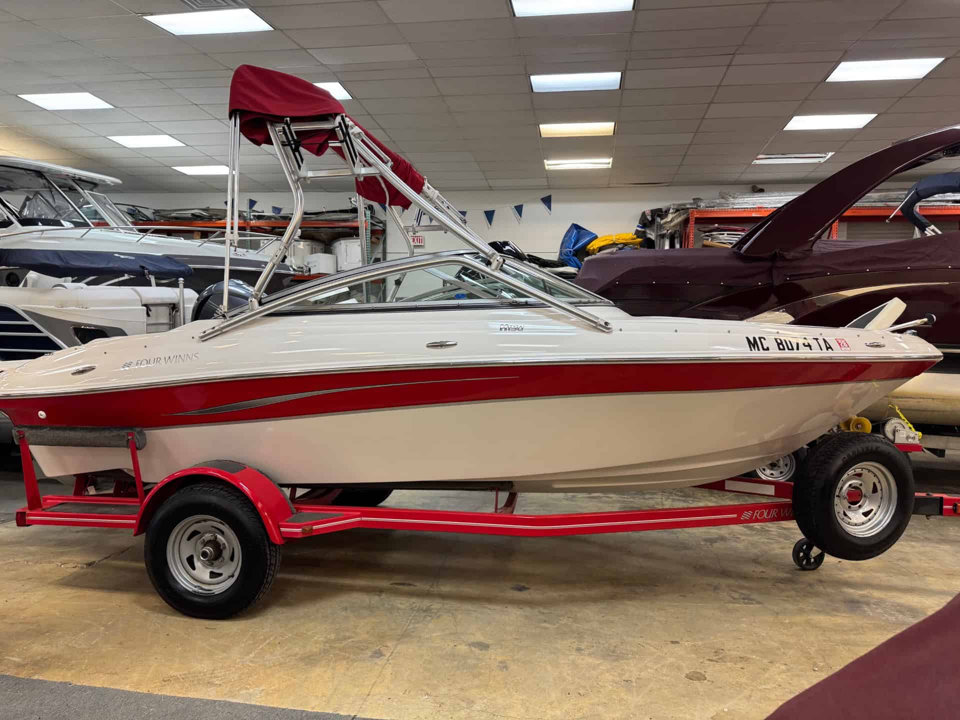 Four Winns H190 boat on a red trailer at Hall's Sport Center.