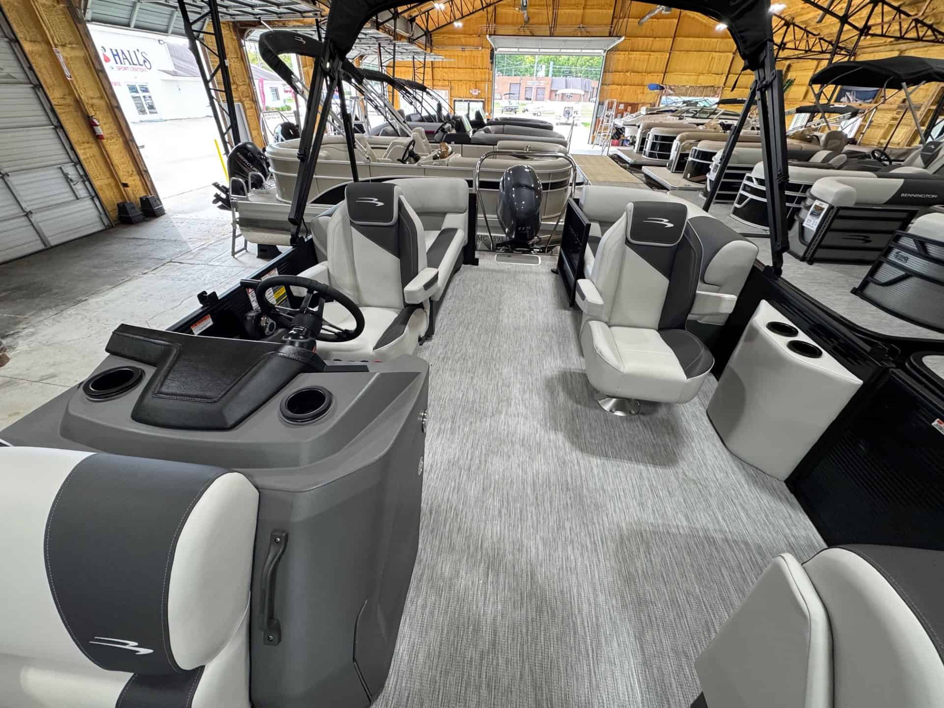 Pontoon boat interior at Hall's Sport Center, showcasing luxury seating and modern controls.