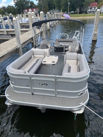 Pontoon boat on the water at Hall's Sport Center, ideal for leisure and water sports.