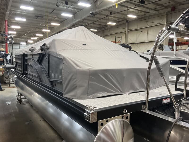 Bennington 22 S1SB pontoon boat covered with protective tarp at Hall's Sport Center. Perfect for fam.