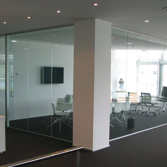 Espacios de oficina modernos con paredes de vidrio y mobiliario corporativo profesional.